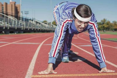 woman in track suit with headband on ready to race