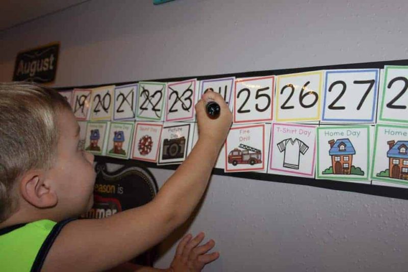 boy putting an x on the calendar with a dry erase marker