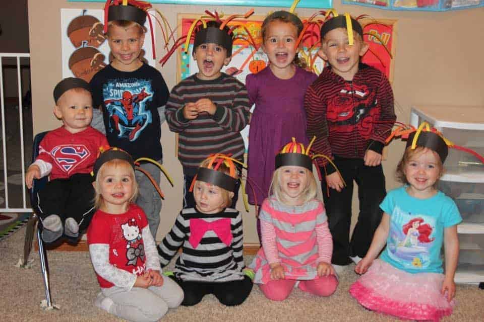 groupe d'enfants d'âge préscolaire souriant avec des chapeaux de feu en papier pour l'idée d'activité de la semaine de sécurité incendie