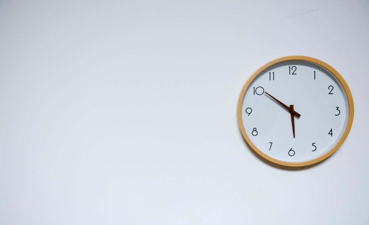 clock hanging on a white wall showing daycare pick up time