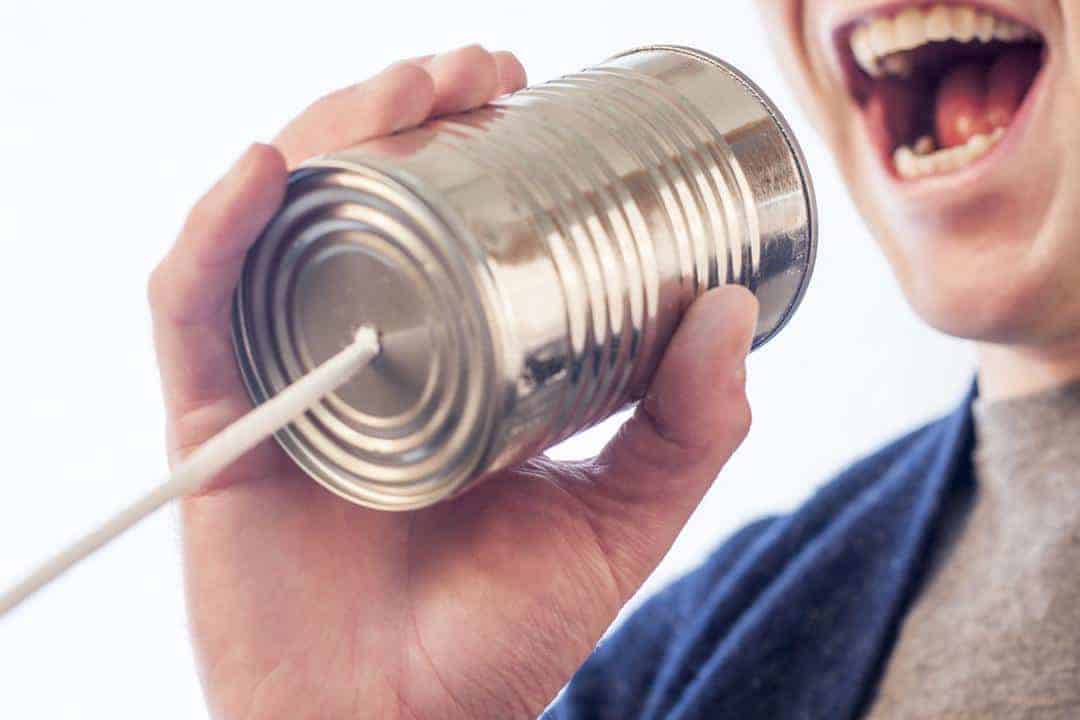 man yelling into tin can phone communicating about a sample daycare contract