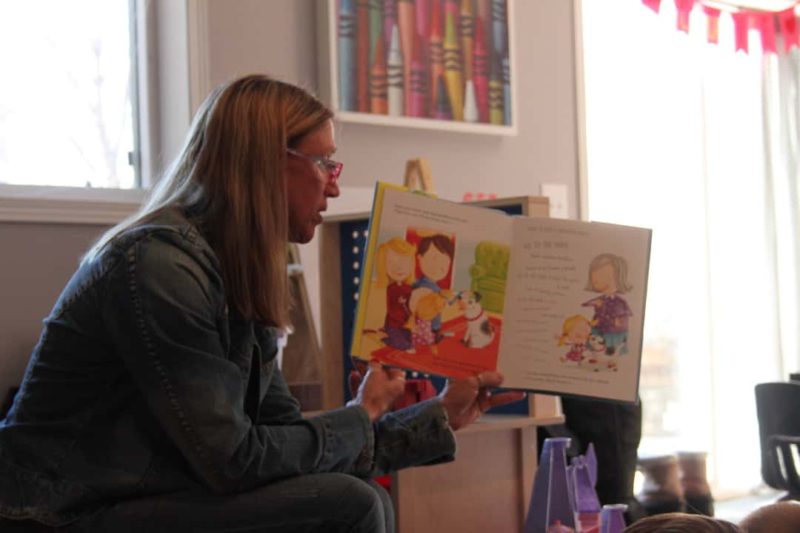 woman reading to a group of kids