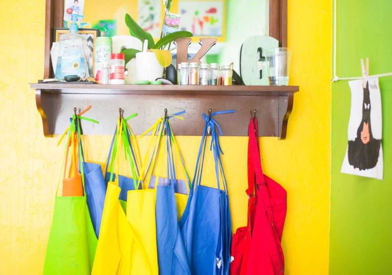 row of colorful aprons hanging in brightly colored classroom