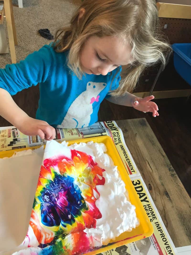 young girl painting with shaving cream