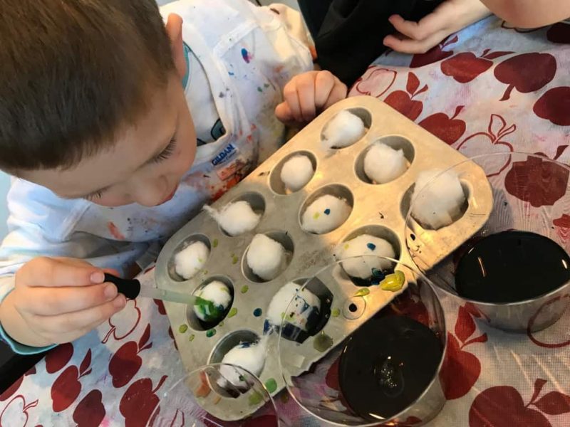 young boy mixing colors with cotton balls and eyedropper