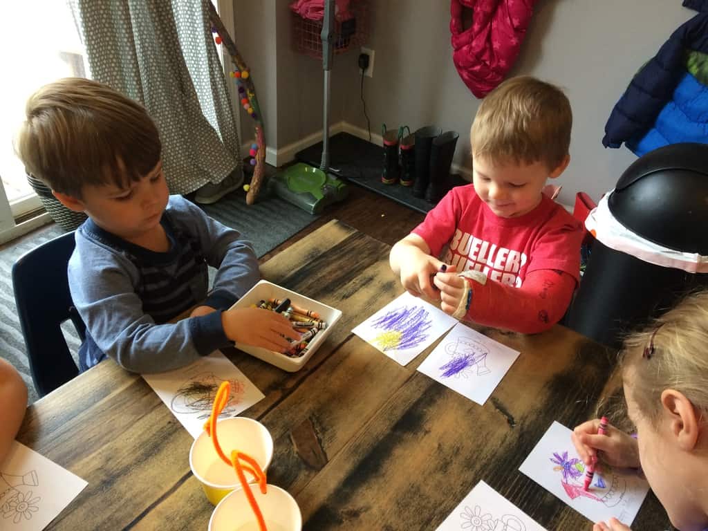 2 boys coloring cards with crayons