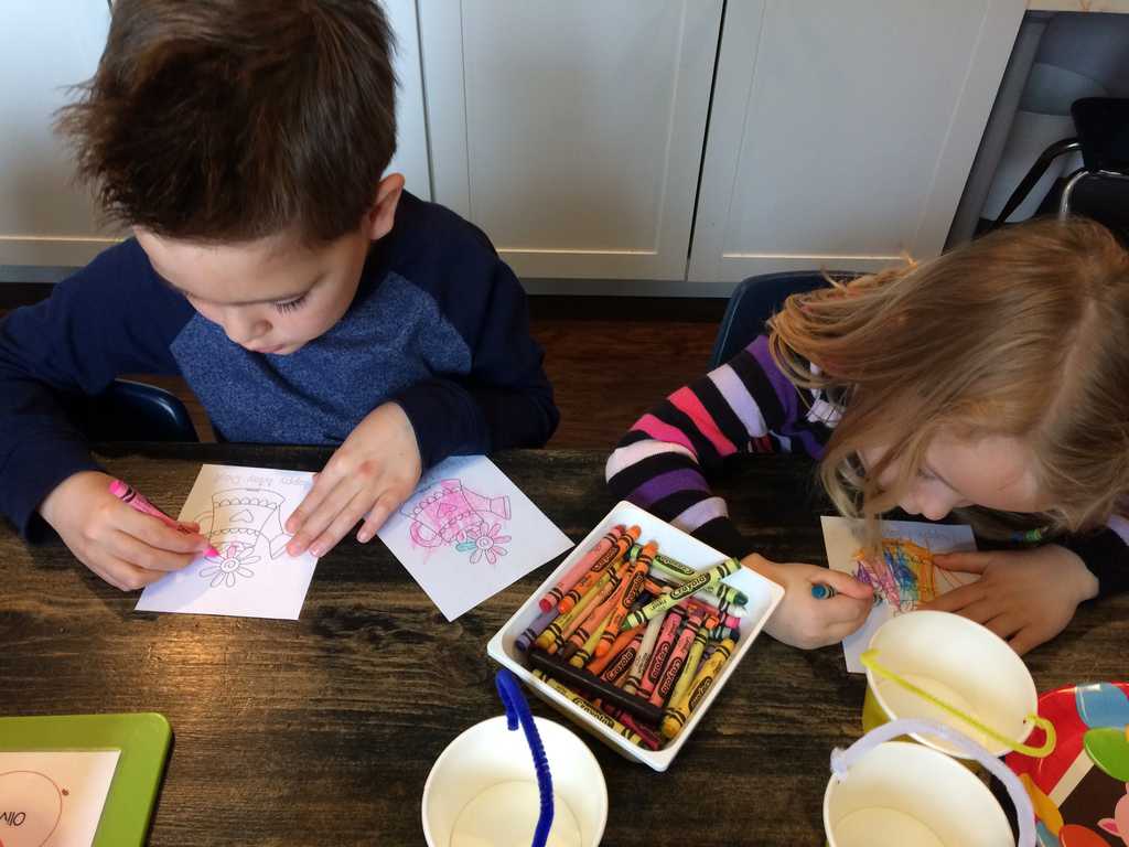 young boy and girl writing notes for the may day basket