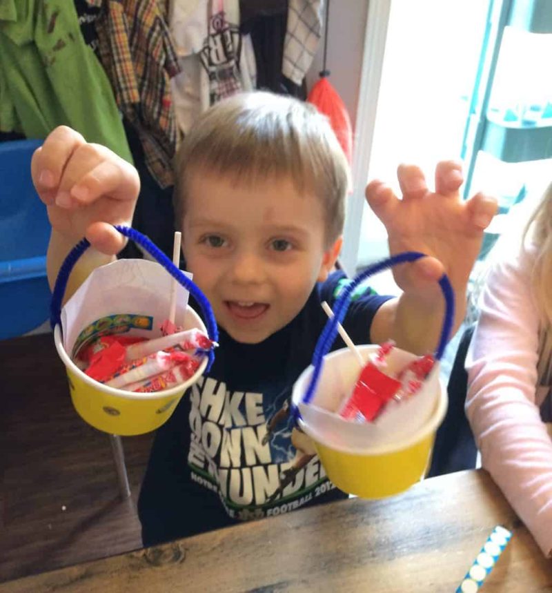 young boy showing off may day basket