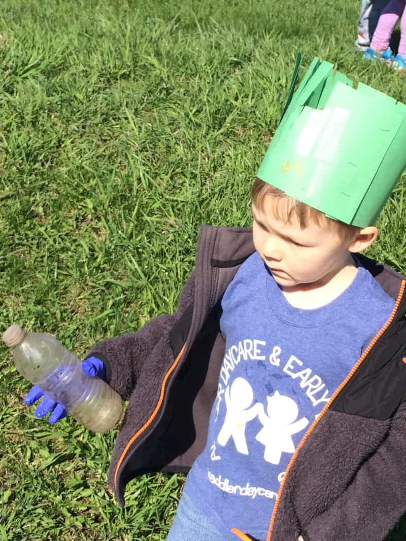 young boy picking up litter during earth day activities