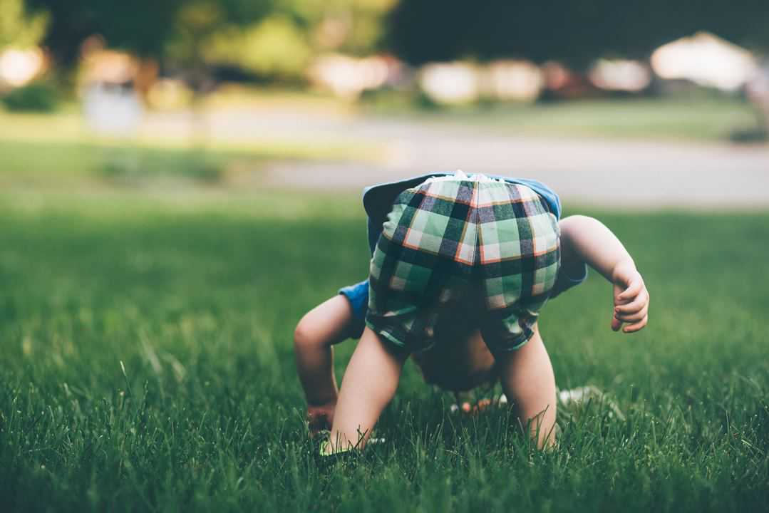 toddler with nose to the grass