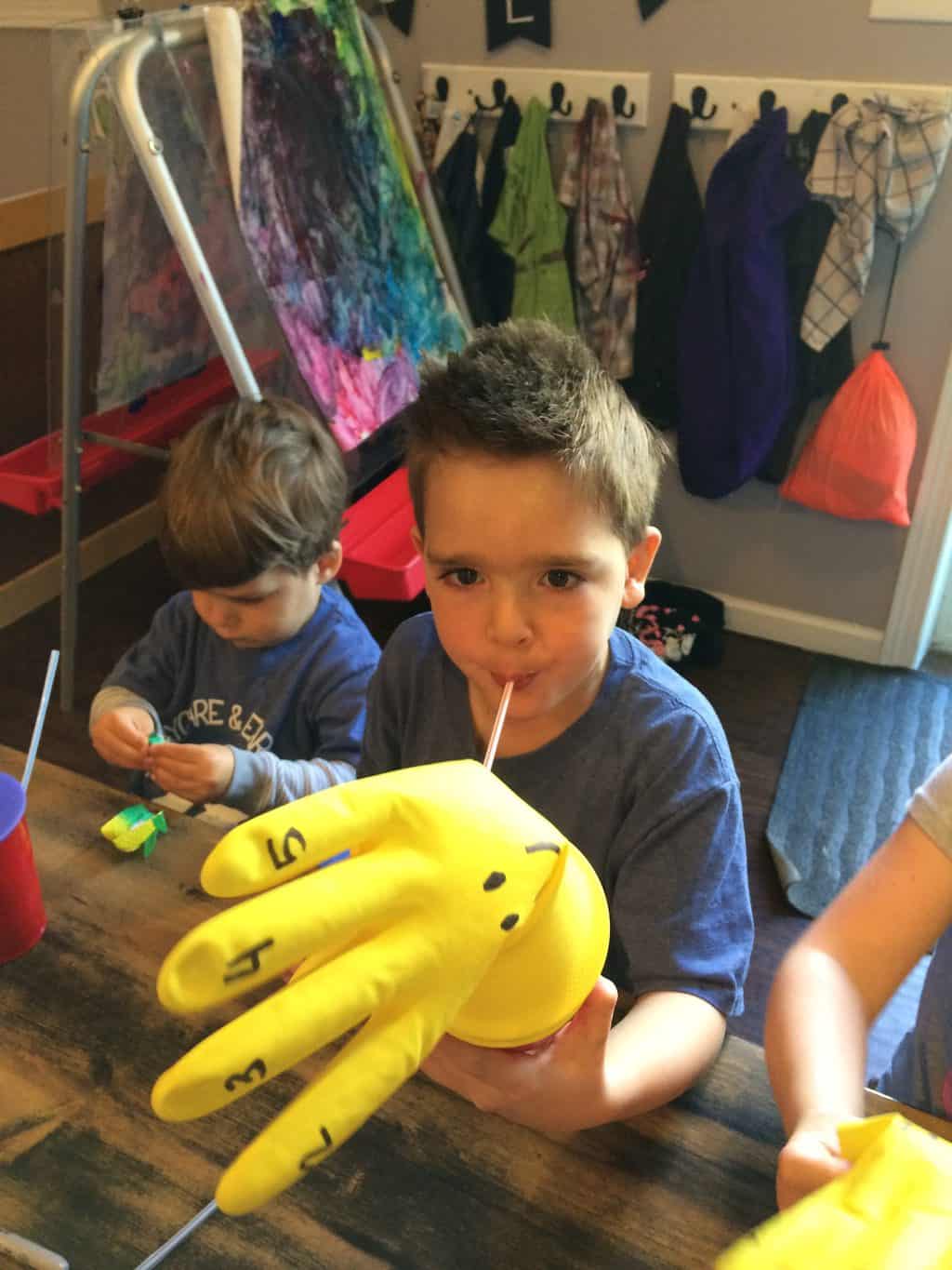 science activity with young boy blowing into a cup