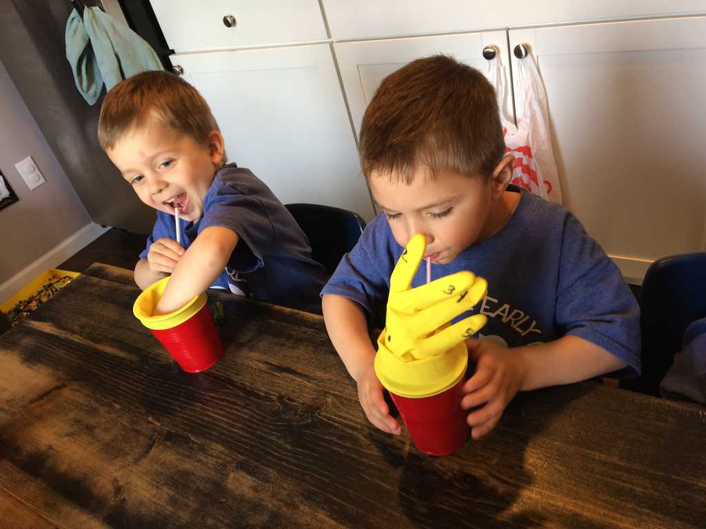 science activity for preschoolers two young boys blowing into  straw and cup