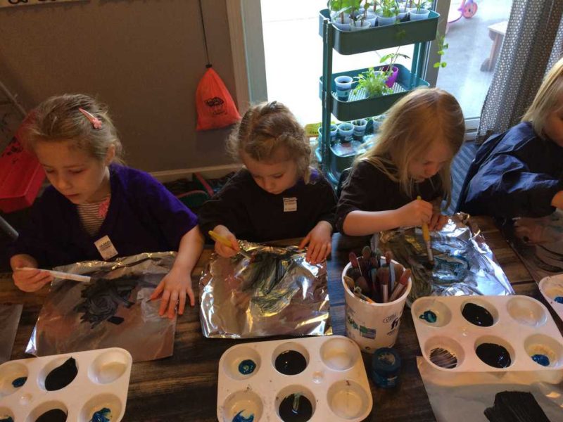 young kids painting on foil during sensory art activity