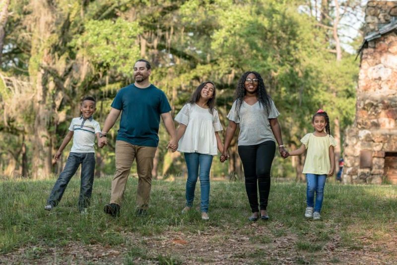 family walking holding hands outside