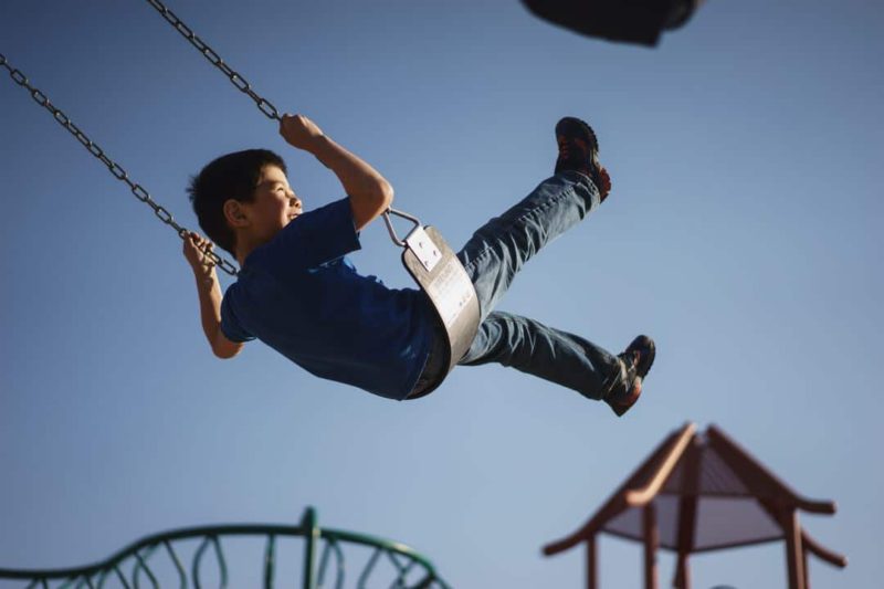 young boy swinging on a swing