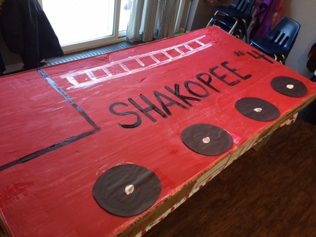 large cardboard painted to look like a giant red firetruck for fire safety craft activity