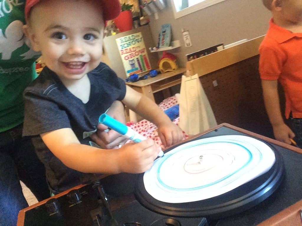 toddler boy holding a marker and grinning