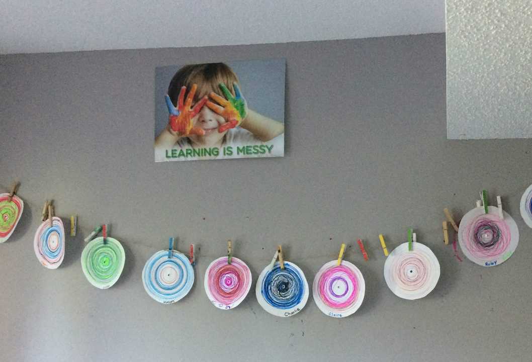 row of colorful circle drawings hanging on a wall