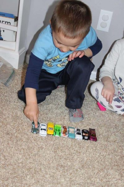 young boy counting toy cars during hands on math activities for preschoolers