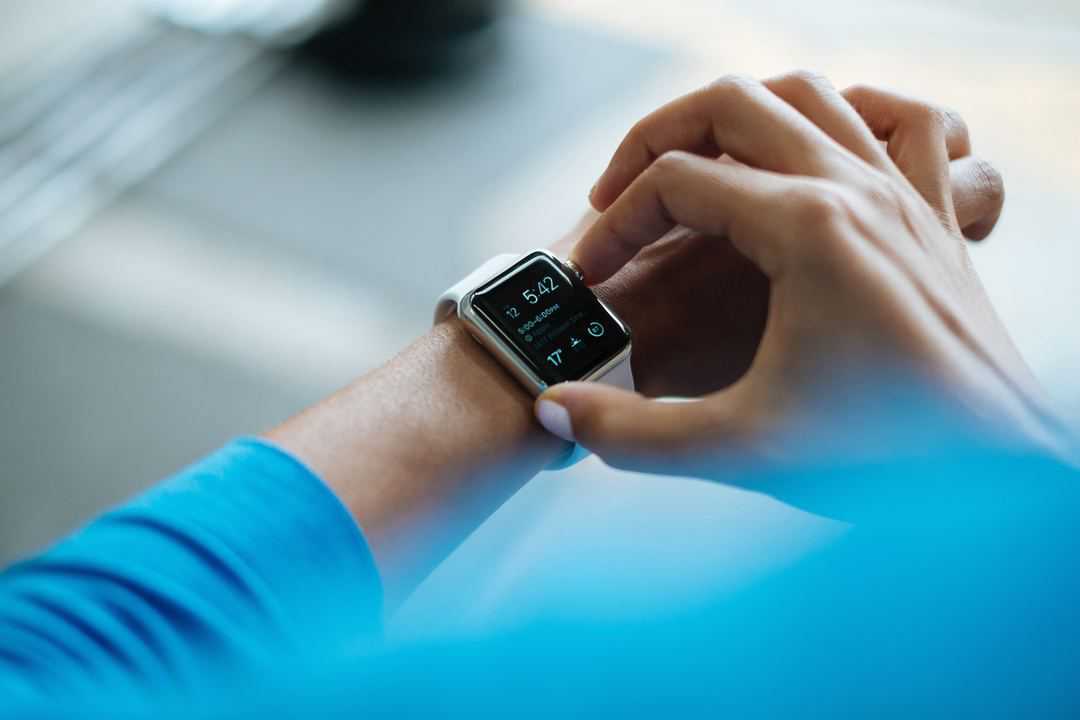 person pushing button on their apple watch