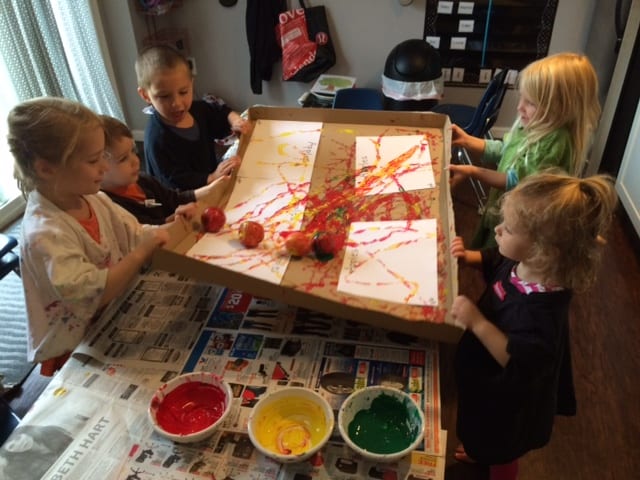 young kids rolling apples in a box apple activity