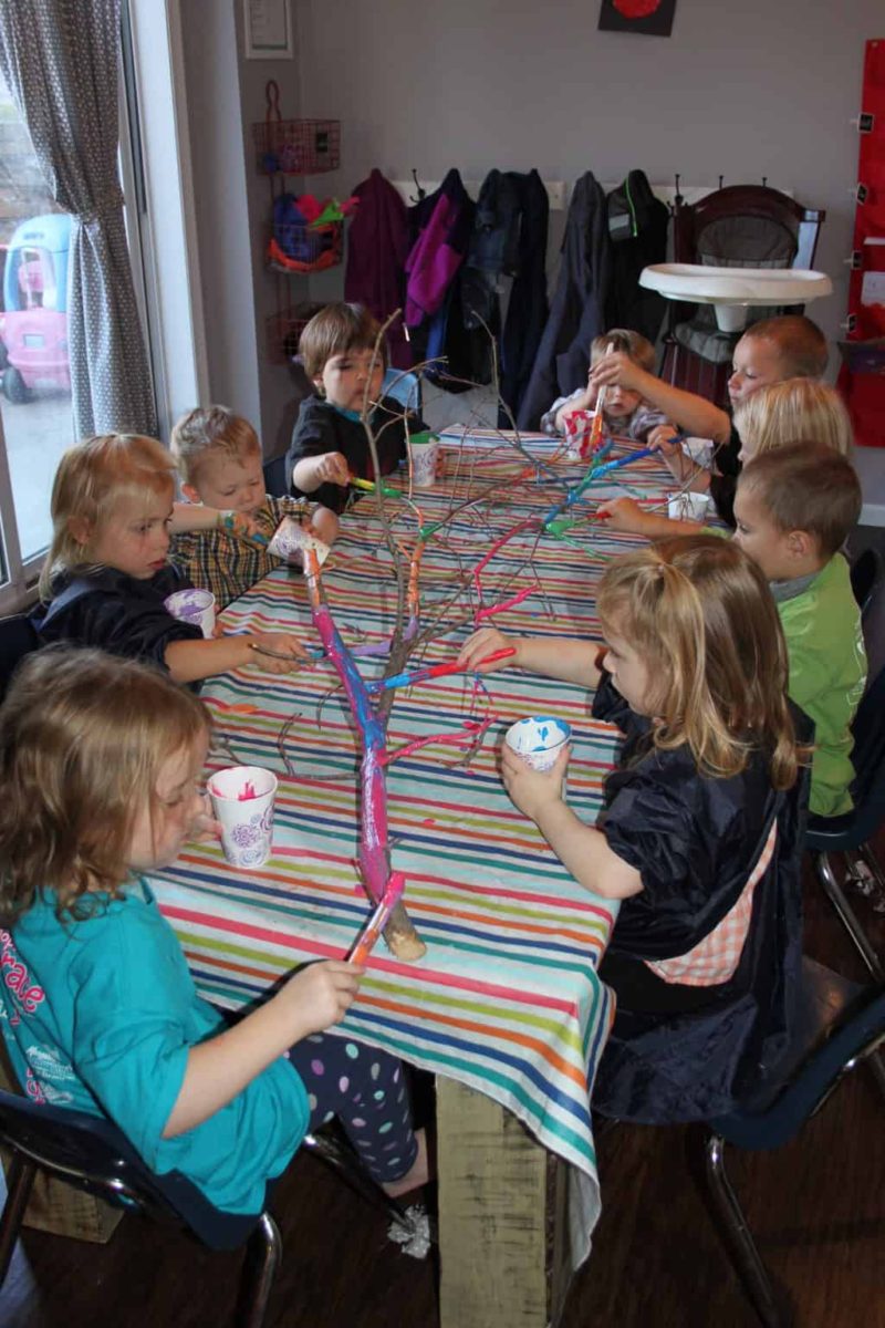 group of preschool kids at art table painting stick for easy art activitiy