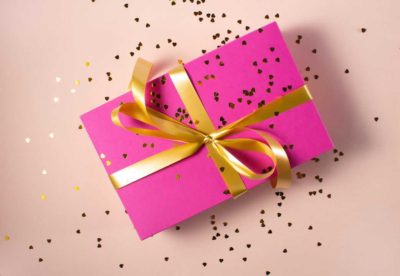 gift wrapped box with pink paper and gold bow