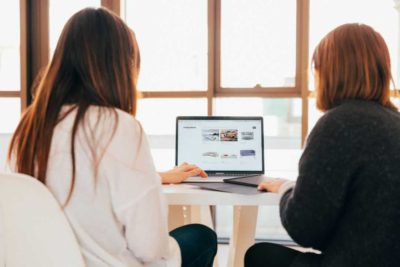 2 women looking at laptop computer