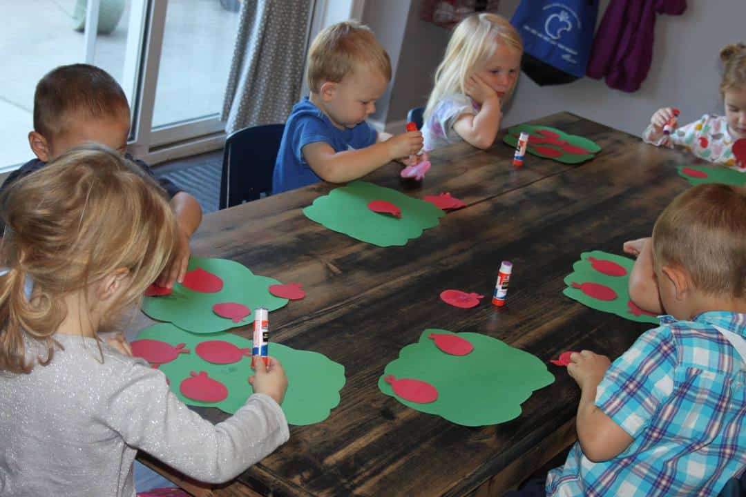 learning about apples gluing paper apples to green paper trees