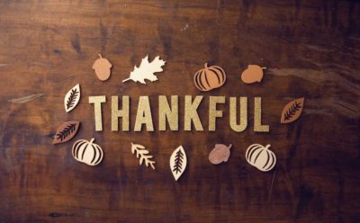 the word thankful on a table with leaf cut outs